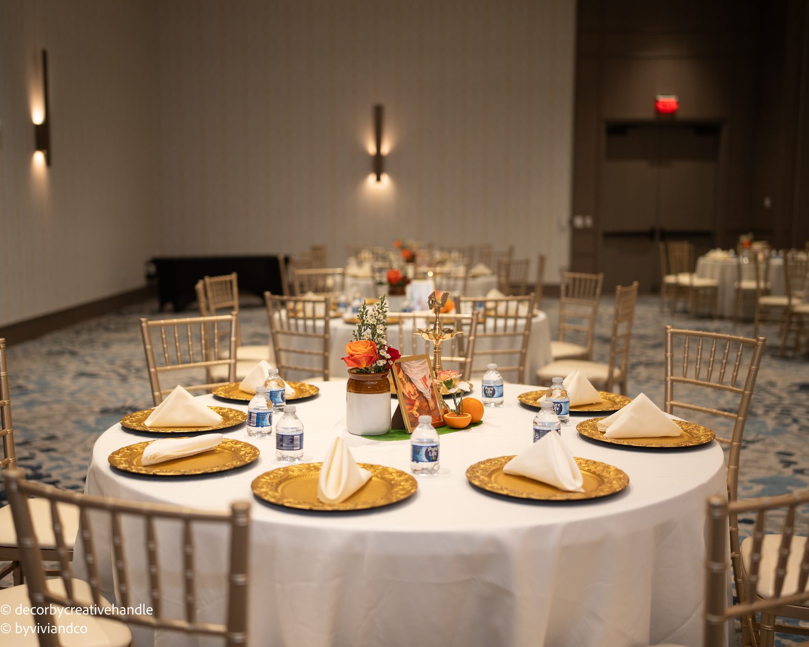 Wedding tablescape with gold place settings and orange floral details