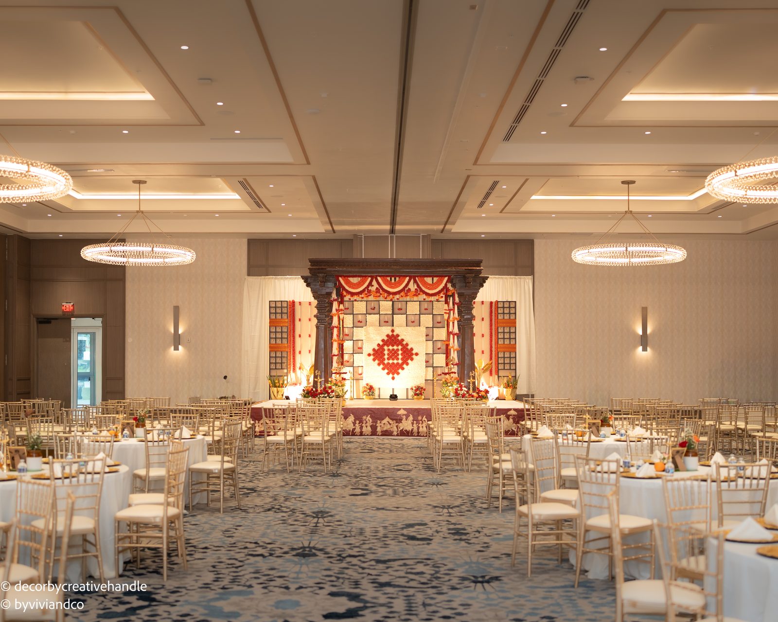Wide wedding setting with a decorated ceremony stage and reception tables