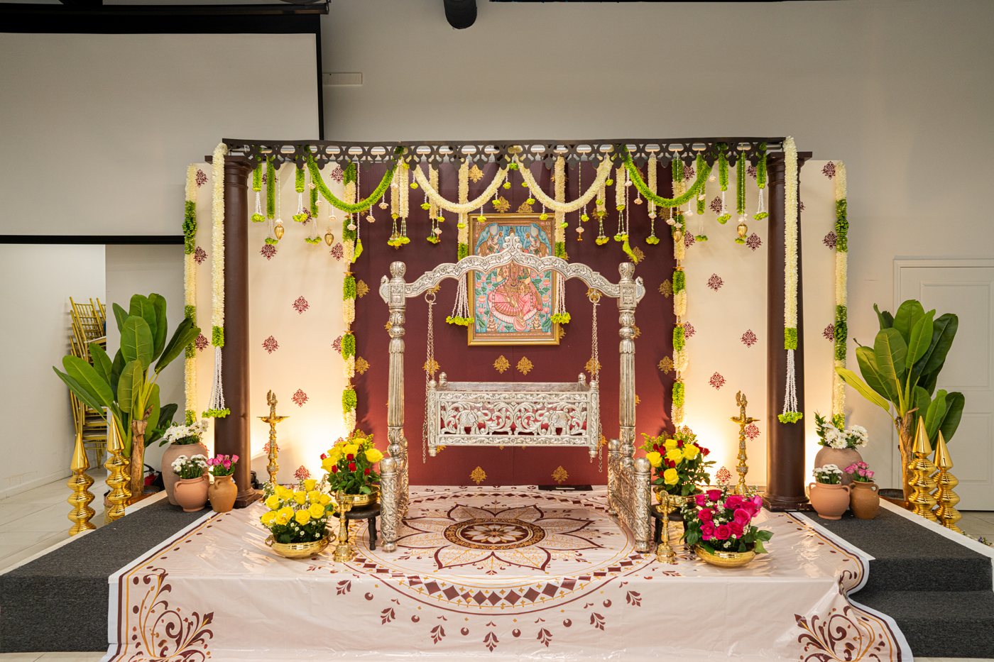 Wide cradle ceremony stage with floral garlands and traditional details